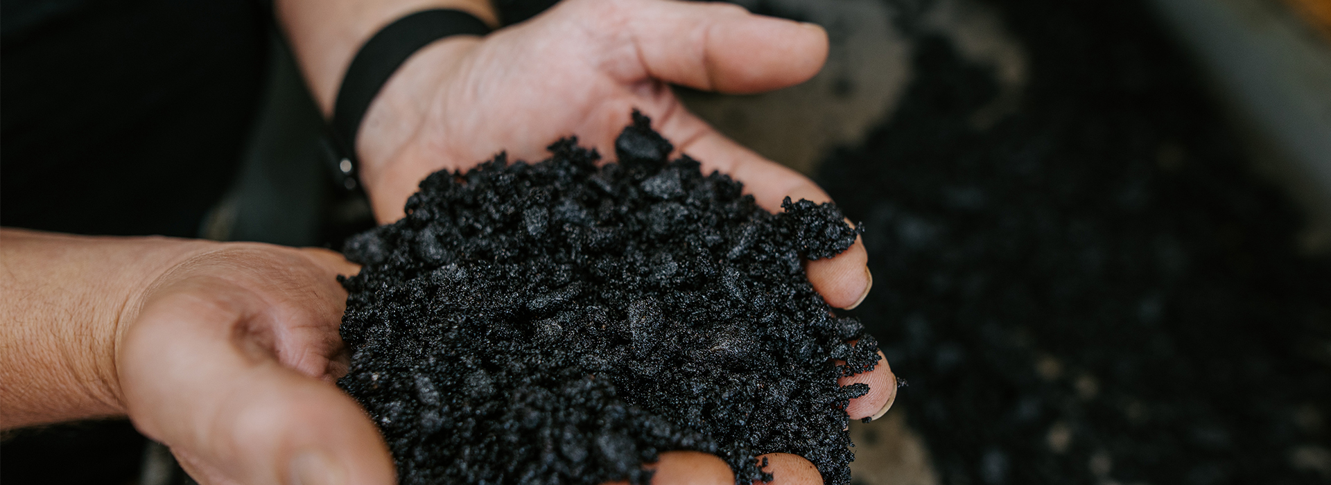 A man holds up the gravel used in asphalt